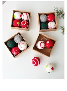 Close-up of handmade wool felt Christmas balls with snowflake embroidery in craft boxes