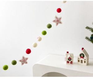 Close-up of wool felt Christmas garland with red green balls and star embroidery