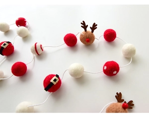 Detailed macro view of felt wool Christmas garland with reindeer and Santa belt balls