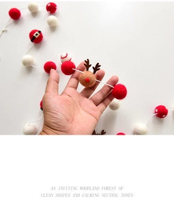 Detail of handmade wool felt Christmas ball garland featuring red and white reindeer balls