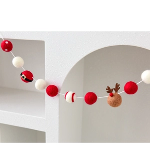 Detail of wool felt Christmas garland with reindeer and Santa belt theme decorative balls