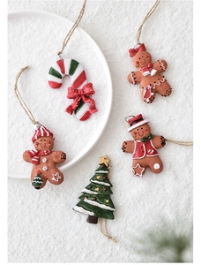Set of 5 resin Christmas ornaments including gingerbread men and tree on snowy texture