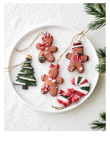 Flat lay of resin gingerbread men and Christmas tree ornaments in faux snow
