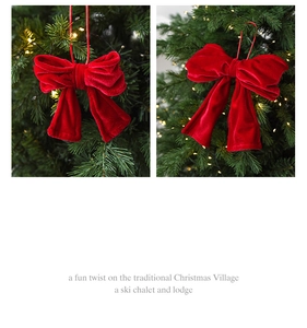Detail view of premium red velvet Christmas bow hanging ornament on a lit tree