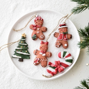 Christmas resin ornament set with gingerbread man, tree, and candy cane on snowy background
