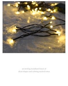 Detail of warm yellow LED string lights with black wires on white decorative snow