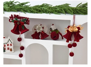Detail of red flocked Christmas bells with bows, pine cones and Merry Christmas text