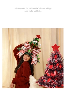 Adult wearing creative Christmas tree hat with red star and bow for festive celebration