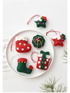 Détail de suspensions de Noël en feutre de laine avec chaussettes et étoiles sur plat