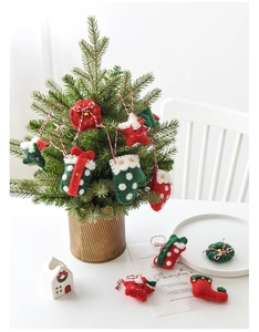 Vue détaillée de décorations de Noël en feutre faites main sur un sapin doré