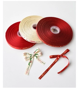Detailansicht von Merry Christmas Satinbändern in Rot und Creme mit festlichen Motiven