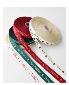 Detail von Weihnachts-Geschenkbändern in Rot, Grün und Beige mit goldenem Aufdruck