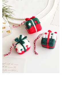 Close-up of three wool felt Christmas gift box ornaments with festive bow details