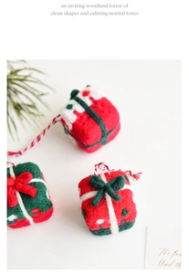 Handmade wool felt mini Christmas gift box ornaments with red and green bows on a white surface