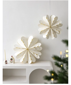 Detailed view of white multi-layered paper star ornaments with golden trim for Christmas
