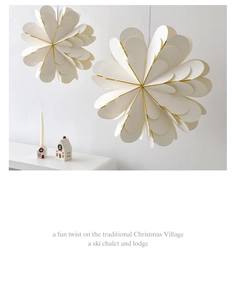 Detail showing white paper snowflake ornament with gold edges and festive string