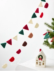 Detail view of colorful wool felt Christmas bunting with handcrafted white stitching details
