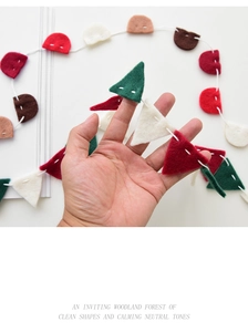 Macro view of wool felt Christmas banner with red and green flags in woodland forest style