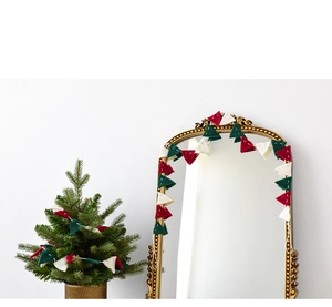 Detail of red and green wool felt Christmas bunting garland hanging on a mirror and tree