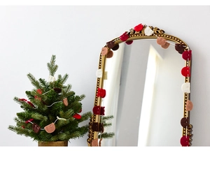 Close-up of colorful felt bunting flags on a Christmas tree and vintage gold frame