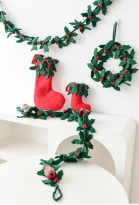 Detail of wool felt Christmas decor set with robin bird, holly leaves, and red berry garland