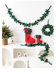 Detail of wool felt Christmas wreath with holly leaves and red berries on a white stand