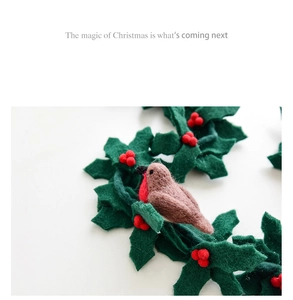 Detailed macro shot of handmade wool felt robin bird with red berries for Christmas
