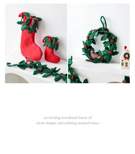 Detailed view of handmade wool felt Christmas stocking and garland with red berries