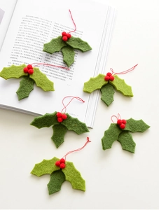 Detailed close-up of six handmade wool felt holly berries with red hanging strings