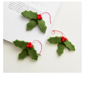 Detailed view of handmade wool felt holly leaves and red berries for Christmas DIY decor