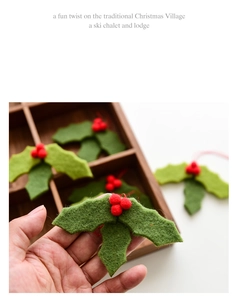 Close-up of handmade wool felt holly leaves with red berries for Christmas decor