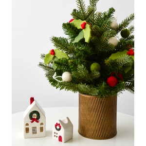 Mini Christmas tree with red berries in bronze pot with ceramic house ornaments
