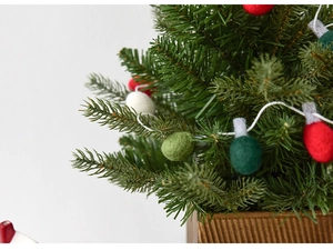 Dettaglio di un mini albero di Natale con decorazioni a lampadina in feltro
