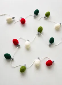 Close-up of wool felt Christmas light bulb string in red, white, and green colors