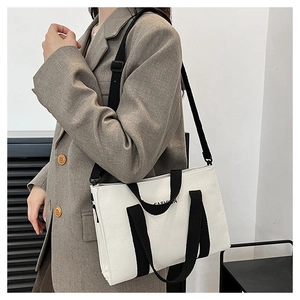 Modella con borsa tote in tela grande con logo FASHION e tracolla regolabile