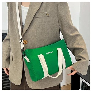 Sac à main en toile verte avec imprimé mode blanc et poignées tissées sur blazer marron