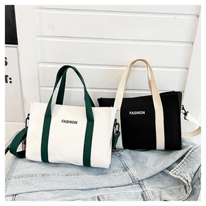 Dettaglio di grandi borse tote in tela con logo FASHION e tracolla staccabile
