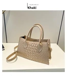 Close-up of khaki PU leather handbag featuring crocodile texture and gold hardware