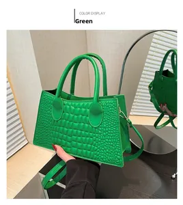 Detail showing bright green crocodile textured handbag with sturdy round handles