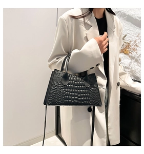 Detail of black faux crocodile texture crossbody bag paired with a white blazer outfit