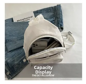 Detail view of large capacity white crossbody bag with dual zippers showing interior storage