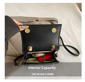 Internal capacity of black leather crossbody bag showing phone and cosmetics