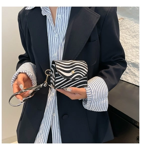 Close-up of zebra pattern handbag with golden snap button and wristlet strap