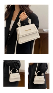 Detail of white crossbody bag with woven knot handle and gold bar accent