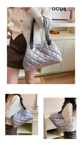 Detailed view of silver quilted tote bag with black leather straps and metallic finish