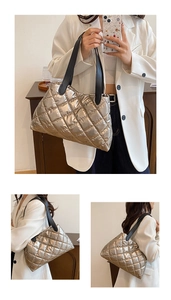Detail of metallic quilted silver handbag showing luxury diamond pattern and black handles