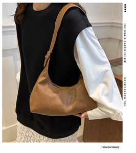 Detail view of a vintage brown faux suede crescent tote bag with vertical stitching accents