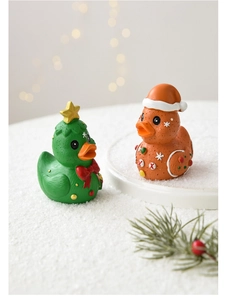Close-up of resin gingerbread duck and Christmas tree duck figurines on snow