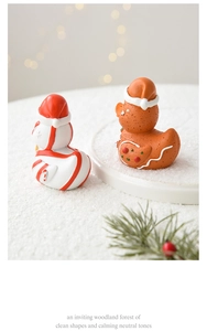 Close-up of resin gingerbread ducks with festive hats and candy cane Christmas details
