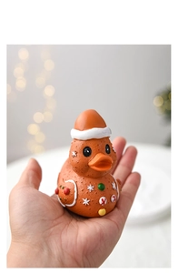 Miniature resin Christmas gingerbread duck figurine held in hand for size display